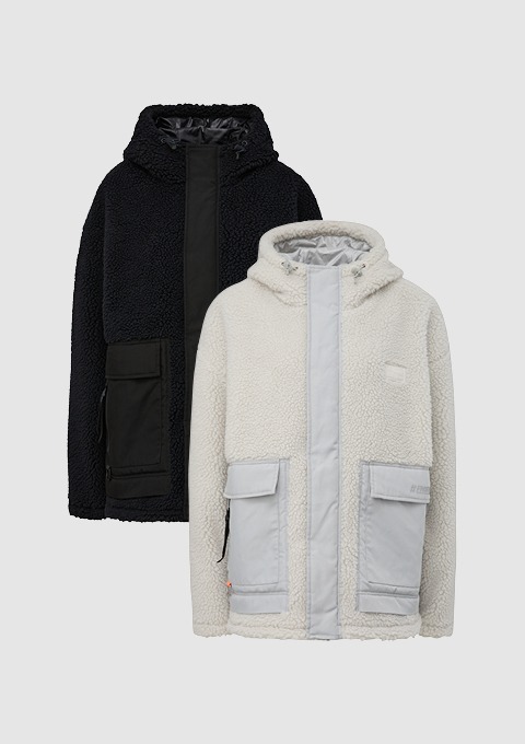 Zwei Fleece-Jacken: eine schwarze und eine beige mit grauen Details. Zwei Fleece-Jacken: eine schwarze und eine beige mit grauen Details.
