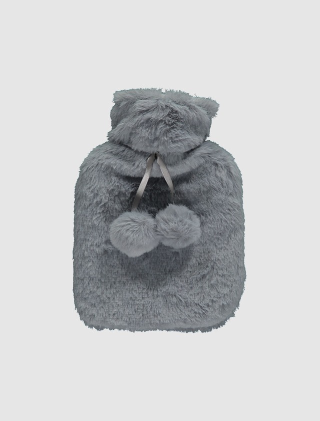 Ein grauer, flauschiger Wärmflaschenbezug mit zwei Pompons. Ein grauer, flauschiger Wärmflaschenbezug mit zwei Pompons.