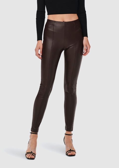 Eine Frau trägt enge, braune Lederleggings und schwarze High-Heels. Eine Frau trägt enge, braune Lederleggings und schwarze High-Heels.