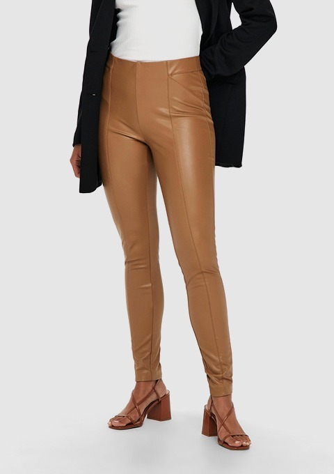 Eine Person trägt eine figurbetonte, braune Lederhose und Sandalen mit Absatz. Eine Person trägt eine figurbetonte, braune Lederhose und Sandalen mit Absatz.