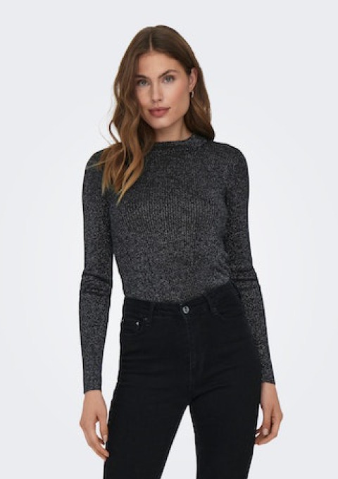 Eine Frau trägt ein schwarzes, glitzerndes Langarmoberteil und schwarze Jeans.