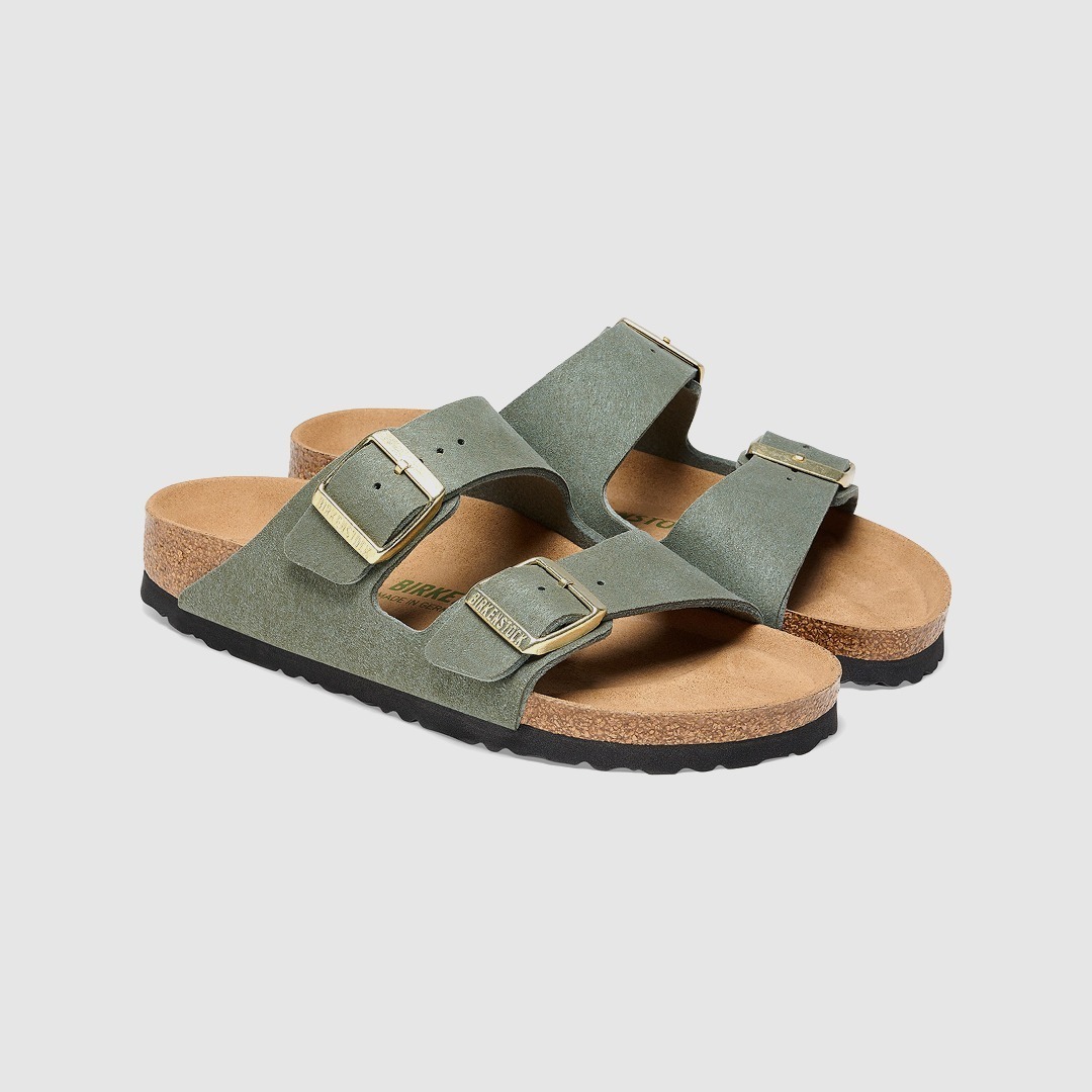 Zwei grüne Sandalen mit zwei Schnallen.
