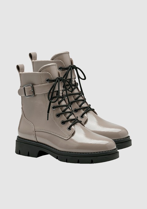 Beige, glänzende Stiefel mit Schnürung und einer Schnalle.