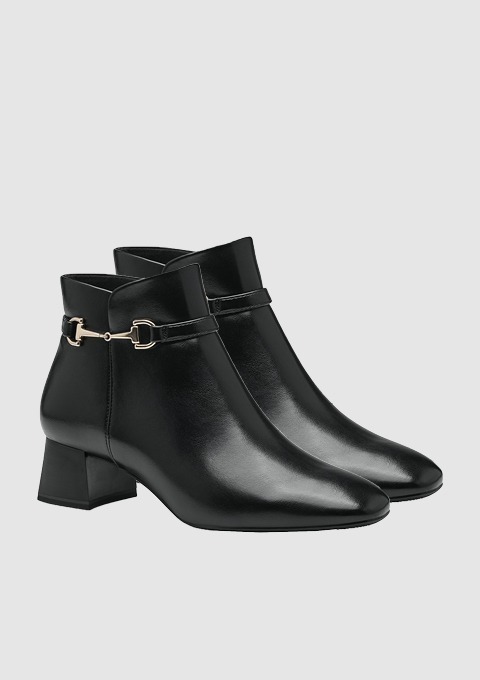 Schwarze Ankle Boots mit Blockabsatz und einem goldenen Schnallen-Detail.