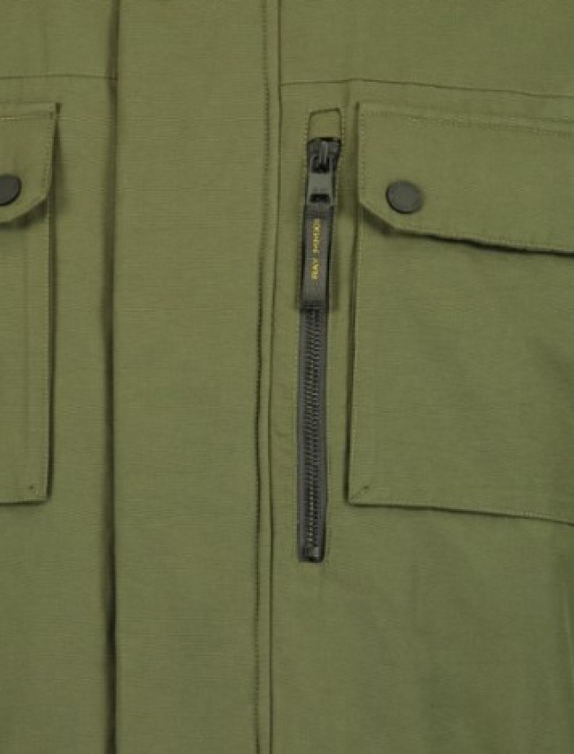 Ein grünes Oberteil mit zwei aufgesetzten Taschen und einem Reißverschluss in der Mitte. Ein grünes Oberteil mit zwei aufgesetzten Taschen und einem Reißverschluss in der Mitte.