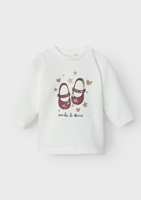 Ein weißes Oberteil mit einem Druck von zwei roten Schuhen und dem Text „smile & shine“, umgeben von Sternen und Herzen. Ein weißes Oberteil mit einem Druck von zwei roten Schuhen und dem Text "smile & shine", umgeben von Sternen und Herzen.