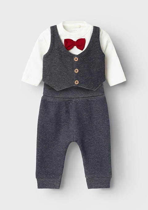 Ein Kinderanzug bestehend aus einem weißen Langarmshirt mit einer roten Schleife und einer grauen Weste mit Knöpfen sowie einer passenden Hose. Ein Kinderanzug bestehend aus einem weißen Langarmshirt mit einer roten Schleife und einer grauen Weste mit Knöpfen sowie einer passenden Hose.