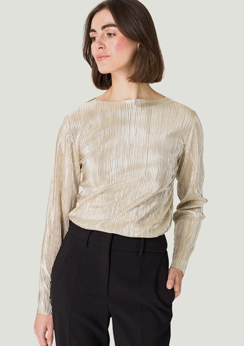 Eine Frau trägt ein elegantes, goldenes Oberteil mit langen Ärmeln, kombiniert mit schwarzen Hosen. Eine Frau trägt ein elegantes, goldenes Oberteil mit langen Ärmeln, kombiniert mit schwarzen Hosen.