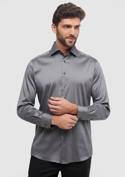 Ein Mann trägt ein elegantes, graues Hemd mit langen Ärmeln. Ein Mann trägt ein elegantes, graues Hemd mit langen Ärmeln.
