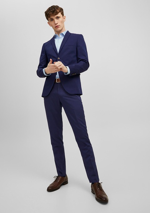 Ein junger Mann in einem dunkelblauen Anzug mit hellblauer Hemd und braunen Schuhen. Ein junger Mann in einem dunkelblauen Anzug mit hellblauer Hemd und braunen Schuhen.