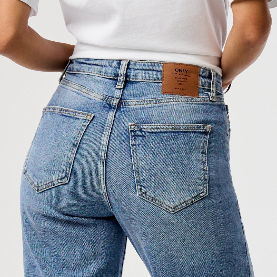 Eine Nahaufnahme des Gesäßes einer Person in hellblauen Jeans mit einem braunen Lederetikett. Eine Nahaufnahme des Gesäßes einer Person in hellblauen Jeans mit einem braunen Lederetikett.