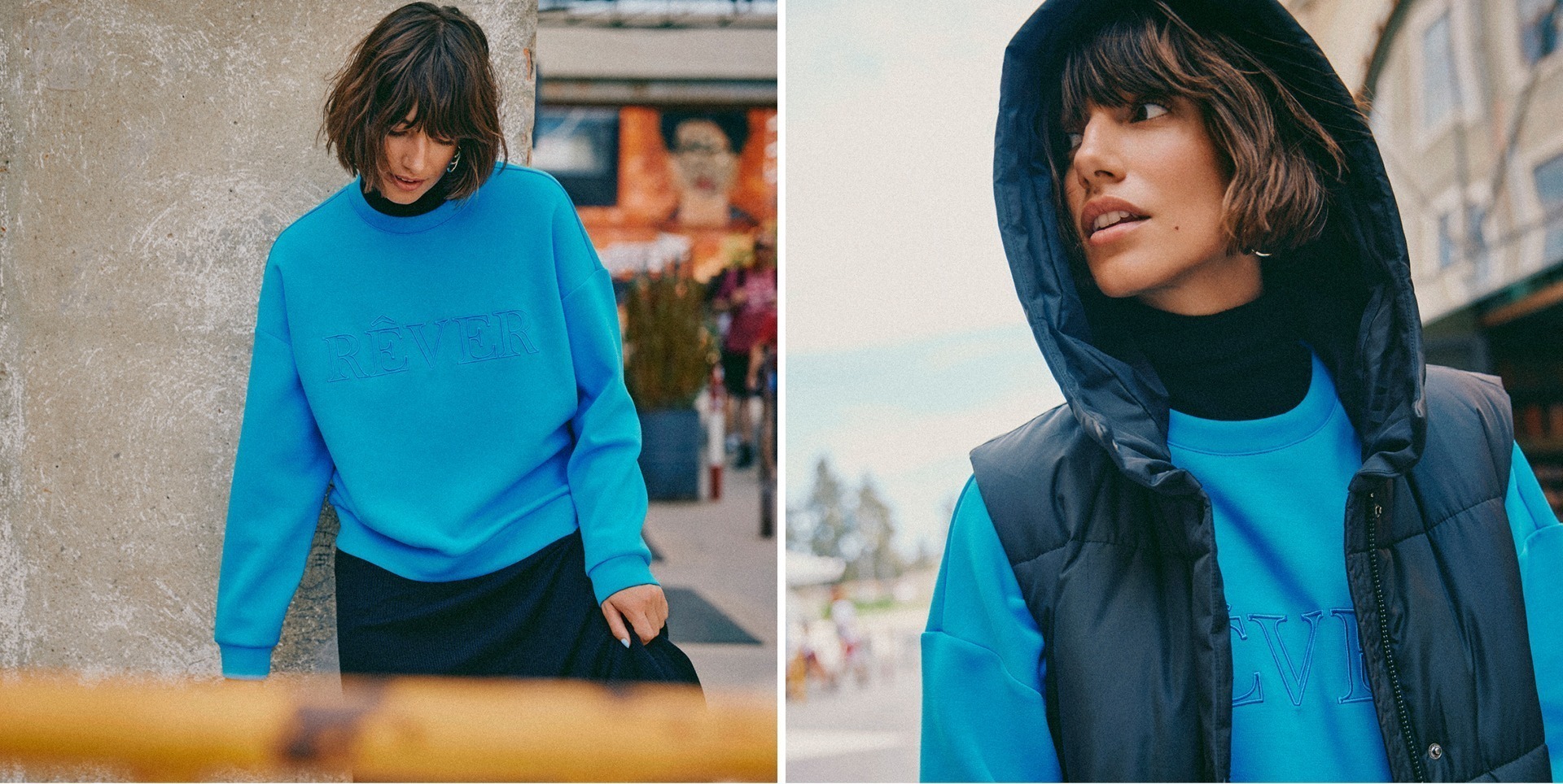 Eine Frau trägt einen blauen Sweater mit dem Wort „RÊVER“ und eine schwarze Weste. Sie ist in einem urbanen Umfeld abgebildet.