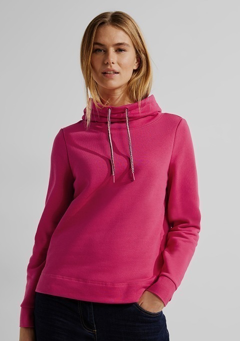 Eine Frau trägt einen pinken Hoodie mit Kordelzug.