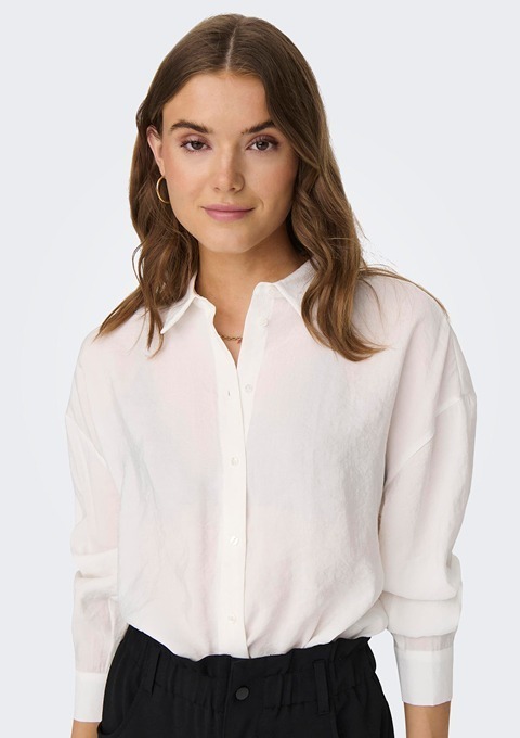 Eine Person mit langem, braunem Haar trägt eine weiße Bluse. Eine Person mit langem, braunem Haar trägt eine weiße Bluse.