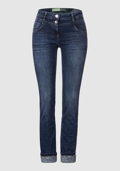 Eine blaue Jeanshose mit schmalem Schnitt und umgeschlagenem Saum. Eine blaue Jeanshose mit schmalem Schnitt und umgeschlagenem Saum.