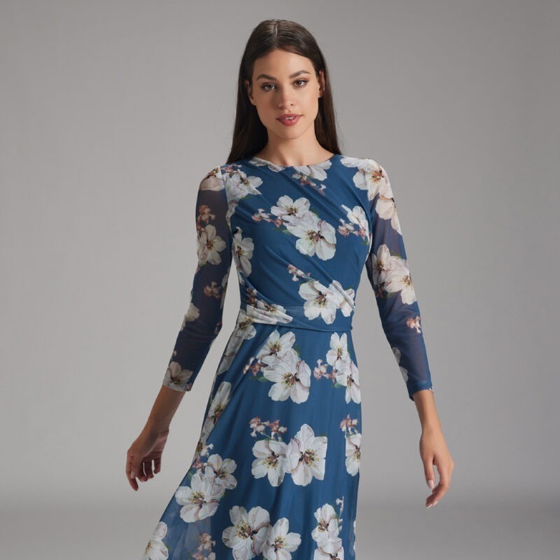 Eine Frau trägt ein langärmliges, blühendes Kleid in Blau.