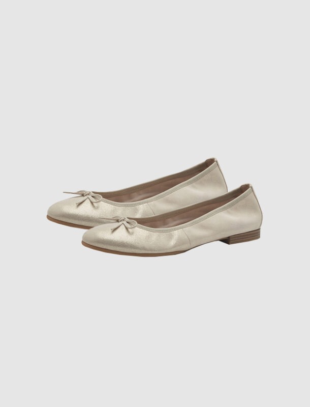 Beige Ballerinas mit einer Schleife.