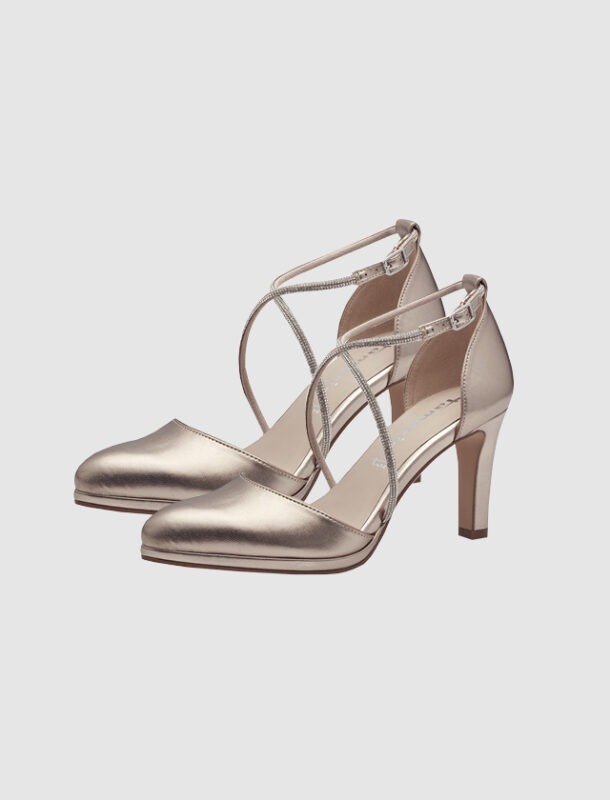 Ein Paar schicke, goldfarbene High Heels mit gekreuzten Riemen.