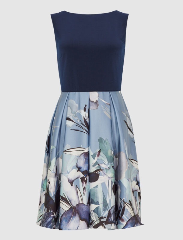 Ein ärmelloses Kleid mit einem blauen Oberteil und einem bedruckten Rock in blauen und grünen Blumenmustern.