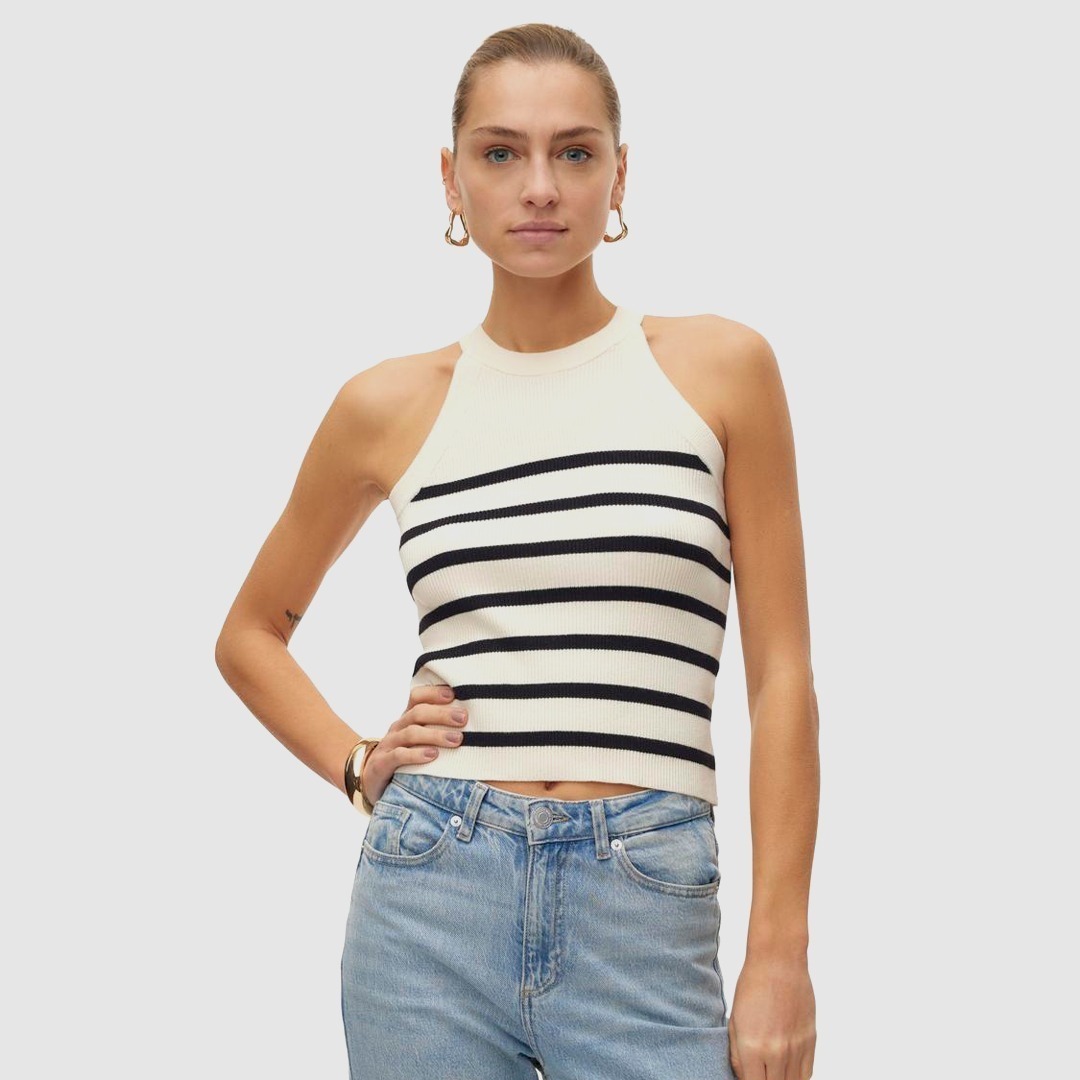 Eine Frau trägt ein ärmelloses, gestreiftes Oberteil in Schwarz und Weiß, kombiniert mit blauen Jeans. Eine Frau trägt ein ärmelloses, gestreiftes Oberteil in Schwarz und Weiß, kombiniert mit blauen Jeans.