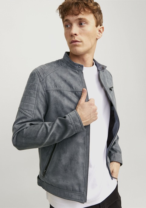 Ein junger Mann trägt eine graue Jacke und schaut nachdenklich zur Seite. Ein junger Mann trägt eine graue Jacke und schaut nachdenklich zur Seite.