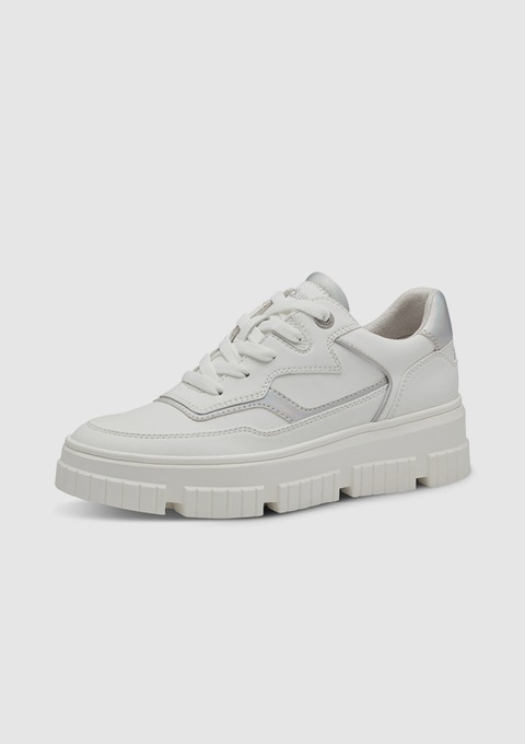 Weiße Sneakers mit dicker Sohle und silbernen Akzenten. Weiße Sneakers mit dicker Sohle und silbernen Akzenten.