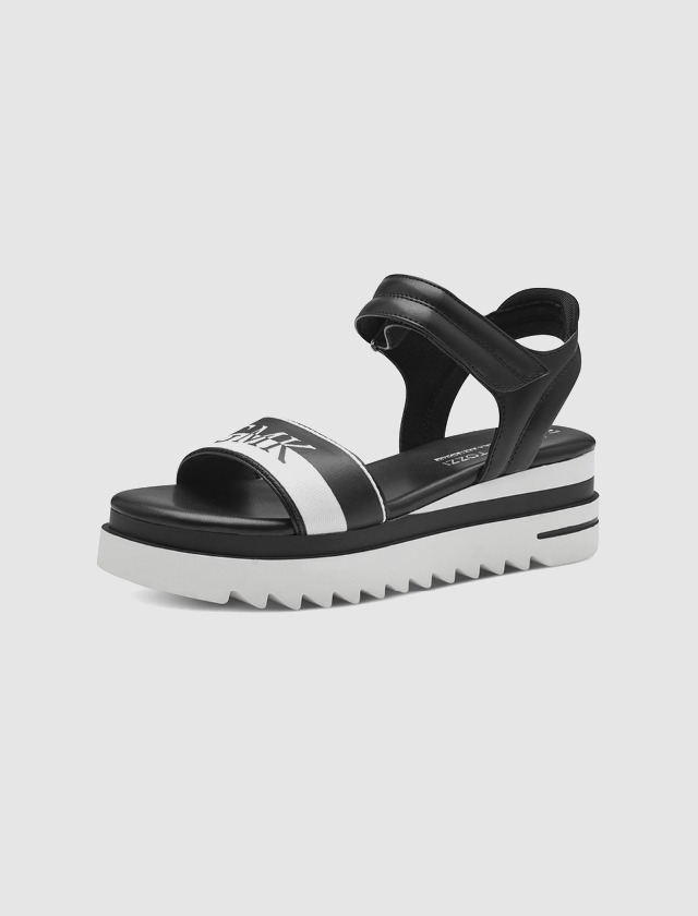 Schwarze Sandalen mit weißen Akzenten und Plattformsohle.