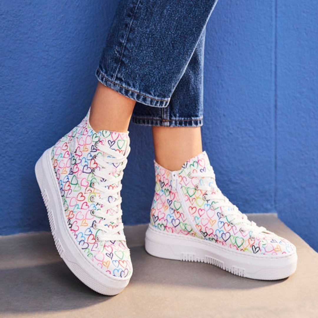 Bunte Sneakers mit Herzmotiv, kombiniert mit Jeans.