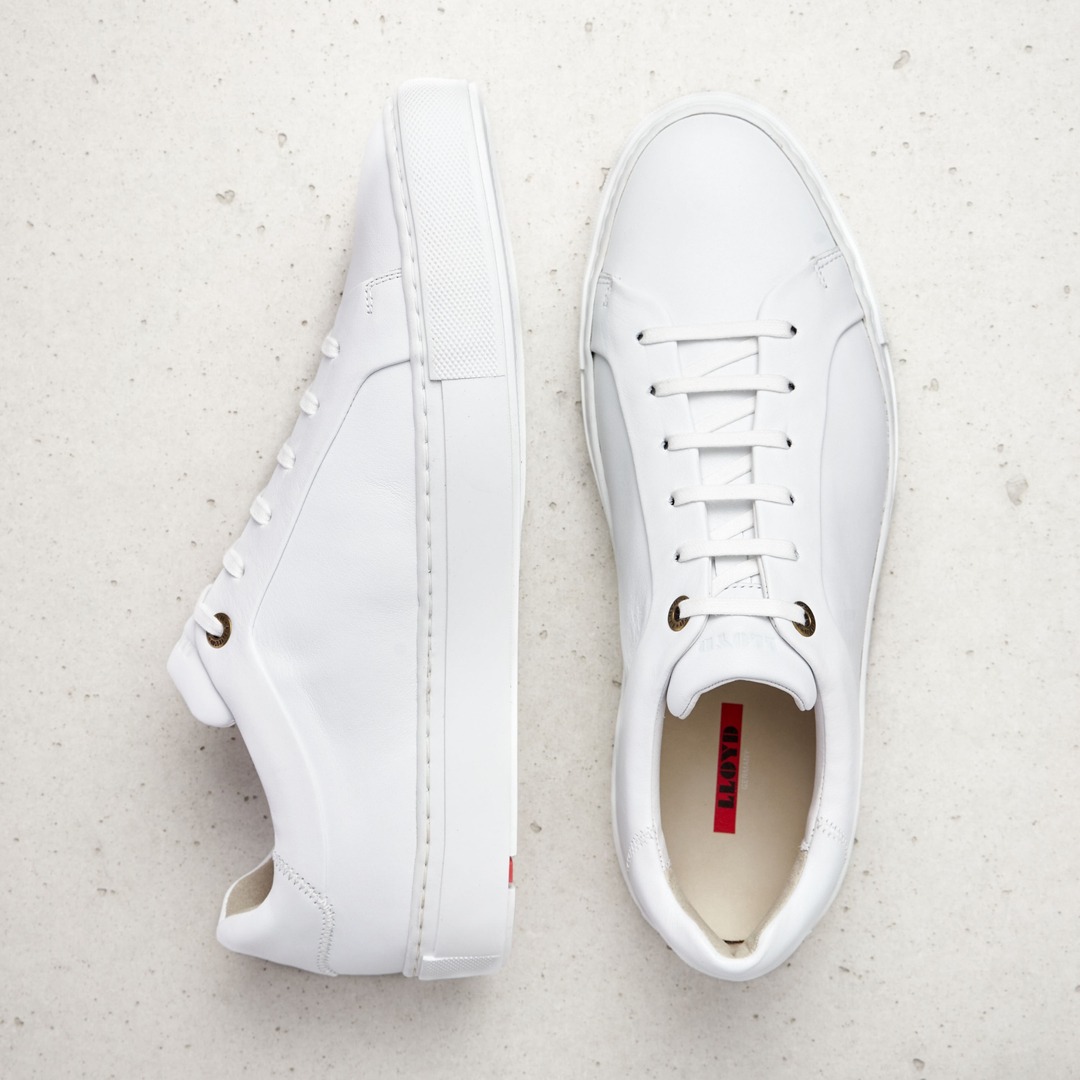 Zwei weiße Sneaker auf einem hellen Hintergrund.