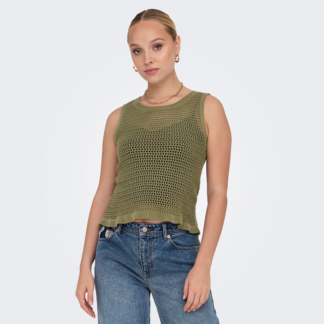 Eine Person trägt ein grünes, gestricktes Top und Jeans.
