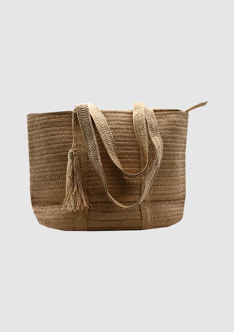 Eine große, geflochtene Tasche aus Jute in hellbrauner Farbe mit einem Quastenanhänger. Eine große, geflochtene Tasche aus Jute in hellbrauner Farbe mit einem Quastenanhänger.