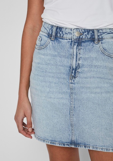 Ein blauer Jeansrock, der bis zur Taille reicht, getragen mit einem weißen T-Shirt.