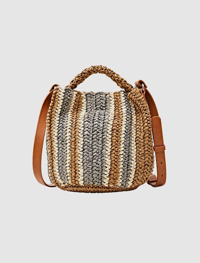 Eine gestreifte Tasche aus Naturmaterialien mit einem ledernen Schultergurt. Eine gestreifte Tasche aus Naturmaterialien mit einem ledernen Schultergurt.