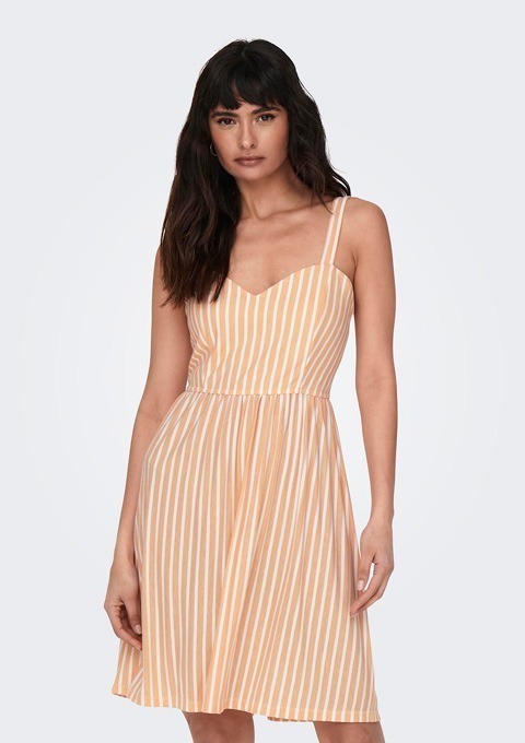 Eine Frau trägt ein orange-gestreiftes Sommerkleid mit Spaghettiträgern.