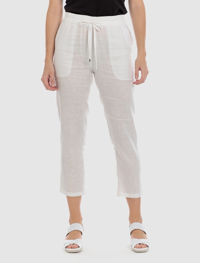 Ein Modell trägt lockere, weiße Hosen und Sandalen auf einer neutralen Hintergrund. Ein Modell trägt lockere, weiße Hosen und Sandalen auf einer neutralen Hintergrund.