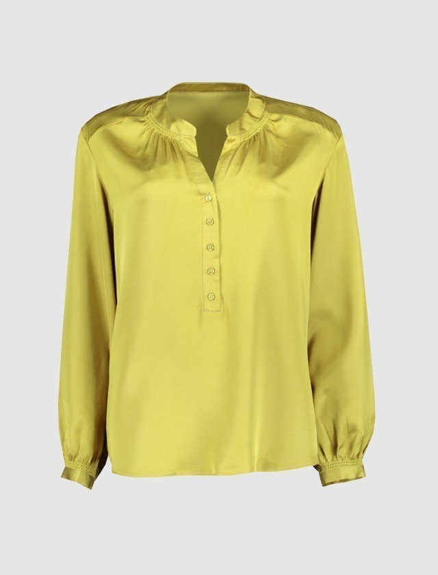 Eine grüne Bluse mit Knopfleiste und langen Ärmeln. Eine grüne Bluse mit Knopfleiste und langen Ärmeln.