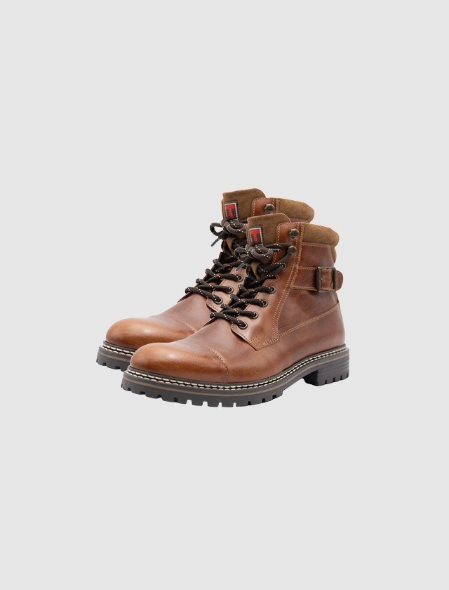 Braune Stiefel mit Schnürsenkeln und verstärkter Zehenkappe. Braune Stiefel mit Schnürsenkeln und verstärkter Zehenkappe.