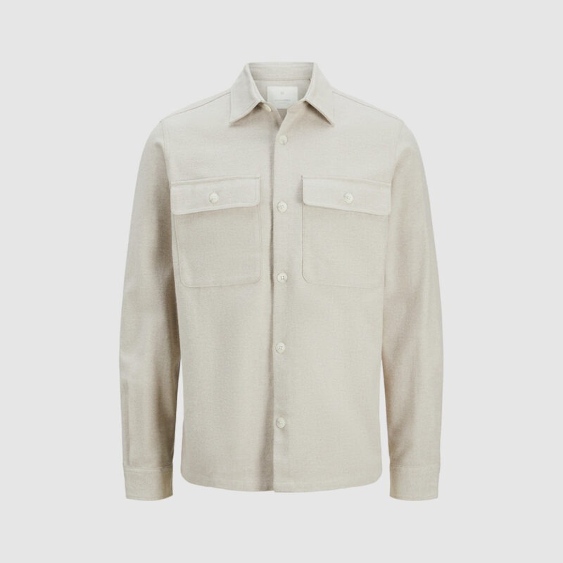 Eine beige Jacke mit zwei Brusttaschen und Knöpfen.