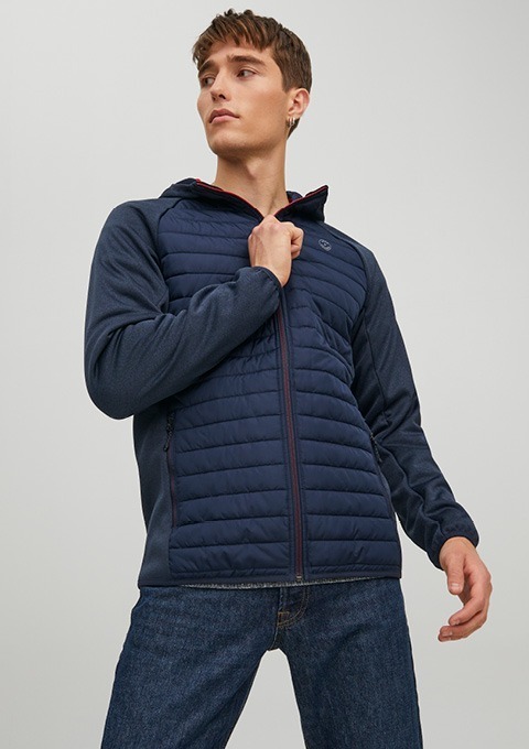 Ein junger Mann trägt eine dunkelblaue Jacke mit Kapuze.