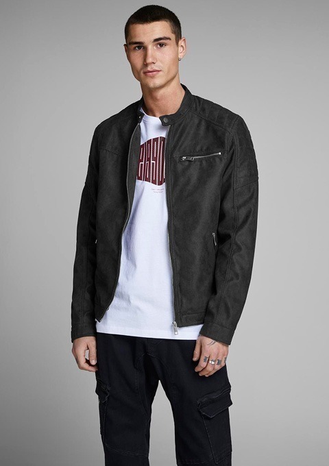 Ein junger Mann trägt eine schwarze Jacke und ein weißes T-Shirt mit rotem Aufdruck.