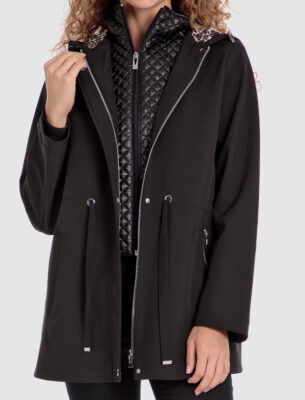 Eine Frau trägt eine schwarze Jacke mit einem gefütterten Innenbereich und einer Kapuze mit einem Leopardenmuster.