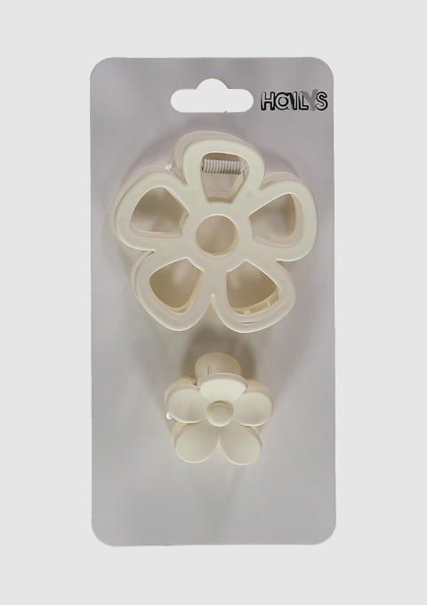 Zwei Blumenhaarklammern in Weiß auf einer Verpackung. Zwei Blumenhaarklammern in Weiß auf einer Verpackung.