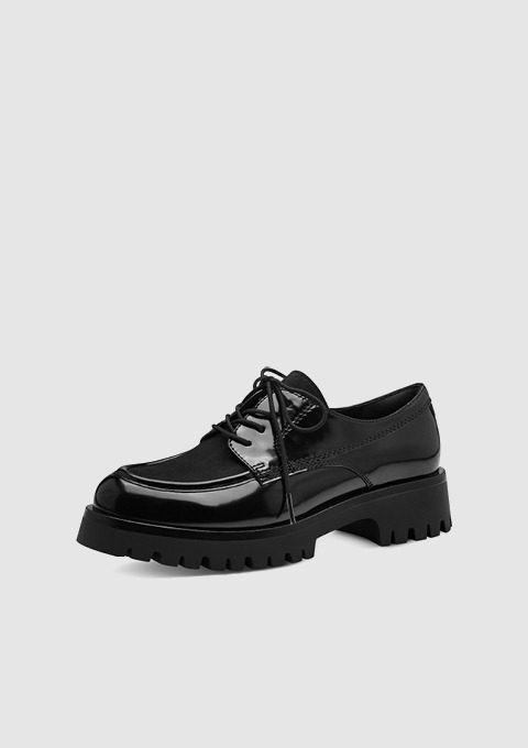 Schwarze, glänzende Schnürschuhe mit dicker Sohle.