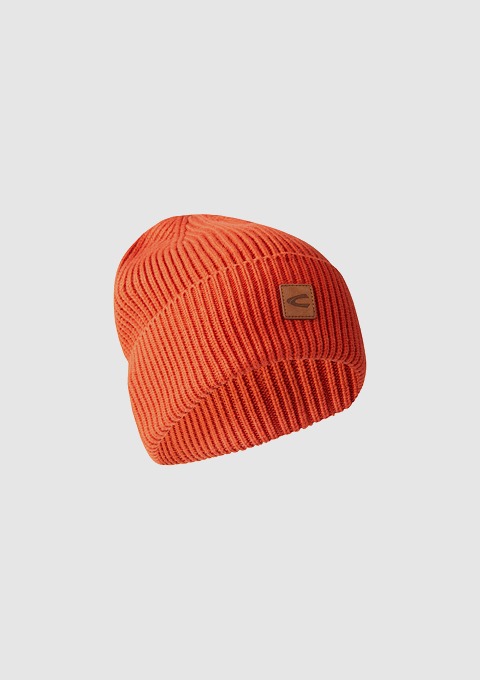 Eine orange Beanie-Mütze mit strukturiertem Muster und einem Logo.