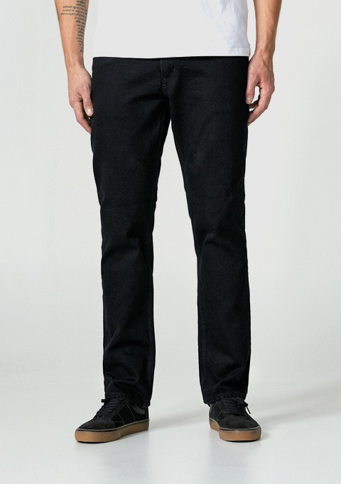 Eine Person trägt schwarze Jeans und schwarze Schuhe.