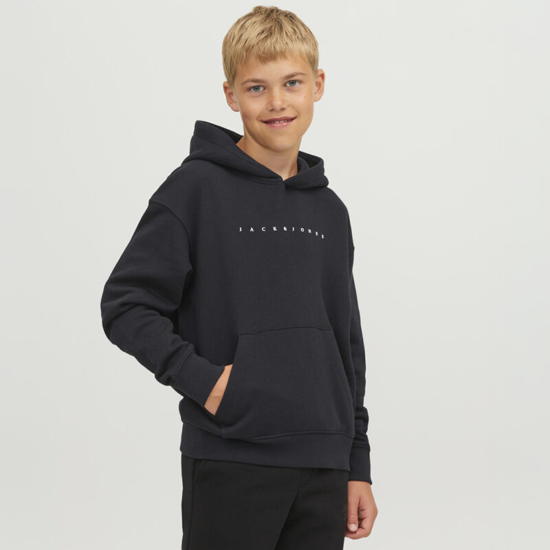 Ein lächelnder Junge trägt einen schwarzen Hoodie mit der Aufschrift "JACK & JONES".