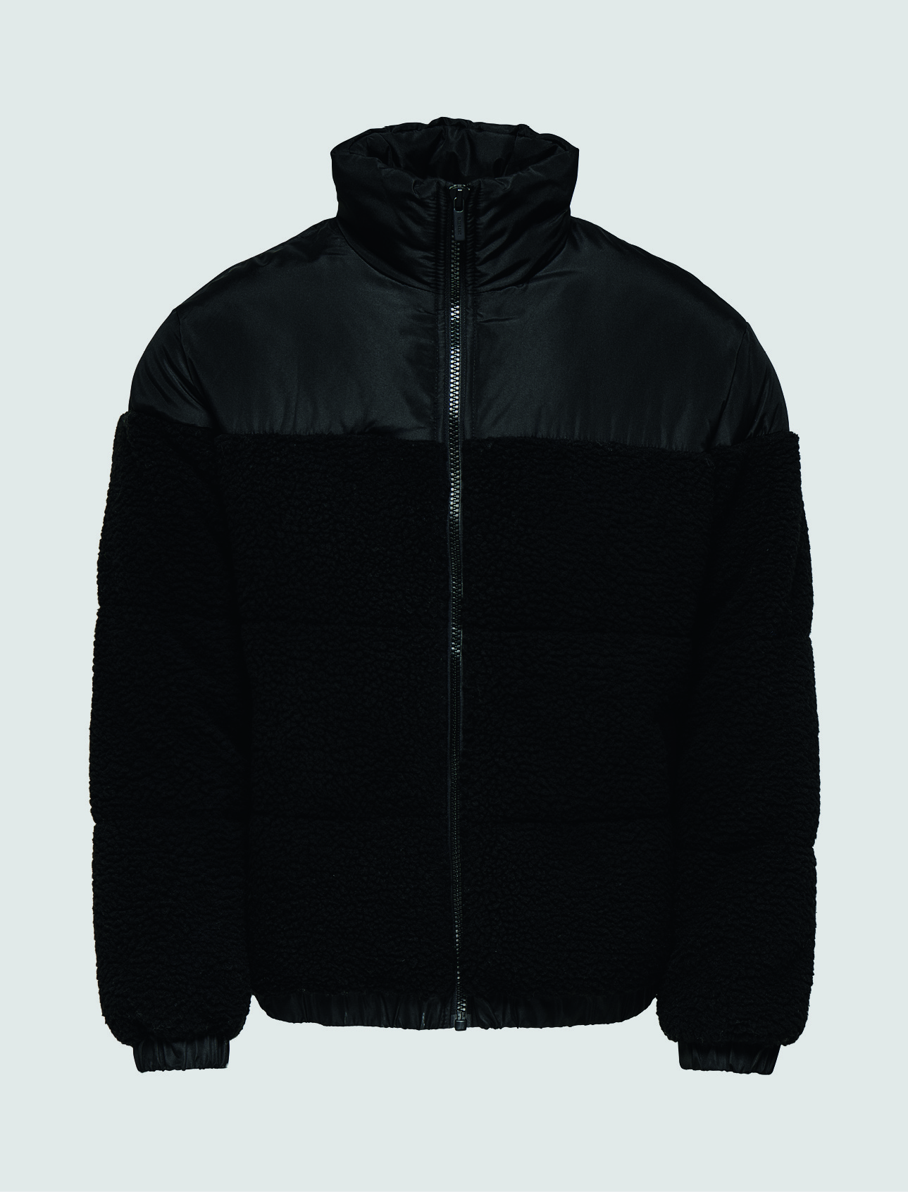 Schwarze Jacke aus einem gemischten Material mit einem oberen Teil aus glattem Stoff und einem unteren Teil aus kuscheligem Material. Schwarze Jacke aus einem gemischten Material mit einem oberen Teil aus glattem Stoff und einem unteren Teil aus kuscheligem Material.