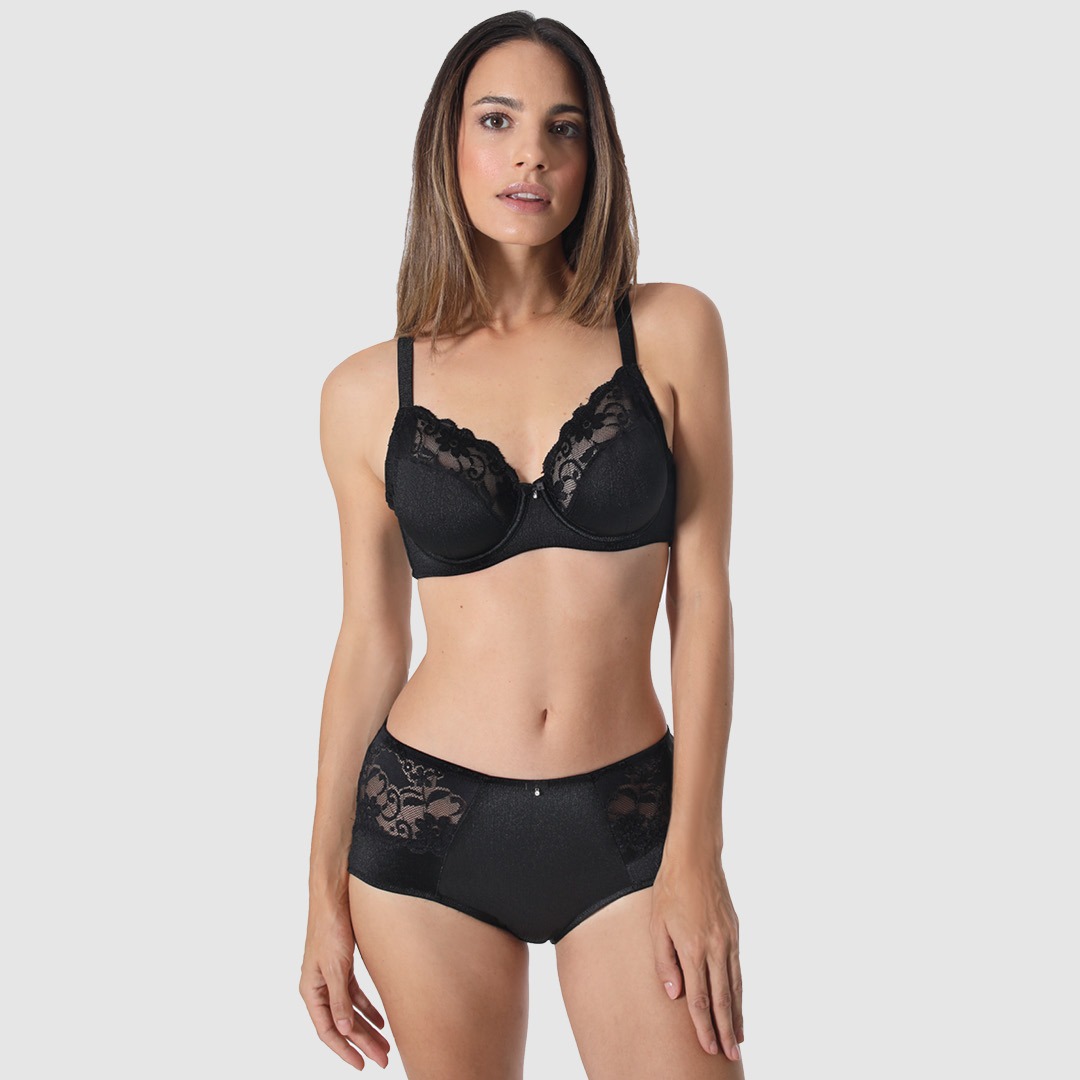 Eine Frau trägt schwarze Unterwäsche bestehend aus einem BH und einem Slip mit Spitzenborten. Eine Frau trägt schwarze Unterwäsche bestehend aus einem BH und einem Slip mit Spitzenborten.