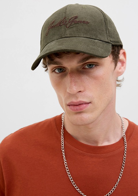Ein junger Mann trägt eine grüne Baseballcap und ein orangefarbenes T-Shirt. Ein junger Mann trägt eine grüne Baseballcap und ein orangefarbenes T-Shirt.